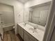 Bathroom boasts double vanity, tub, and updated flooring at 771 Gelderland Dr, Hampton, GA 30228