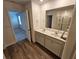 Double vanity bathroom with a large mirror and wood-look flooring at 771 Gelderland Dr, Hampton, GA 30228