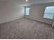 Well-lit bedroom with carpet flooring and two windows at 771 Gelderland Dr, Hampton, GA 30228