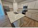 Modern kitchen with white cabinets, granite countertops, and island with sink at 771 Gelderland Dr, Hampton, GA 30228