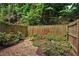 A backyard with gravel and stone walkways, along with a wooden fence and greenery at 1390 Stirling Nw Cir, Atlanta, GA 30318