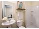 Bathroom featuring a pedestal sink, shelf, decorative art, and shower with white tile at 1390 Stirling Nw Cir, Atlanta, GA 30318