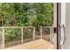 Outdoor deck with metal railing overlooking a private wooded backyard, accessible from sliding glass doors at 1390 Stirling Nw Cir, Atlanta, GA 30318