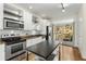 Bright kitchen features stainless steel appliances, granite counters, and center island with sliding doors to the deck at 1390 Stirling Nw Cir, Atlanta, GA 30318