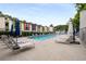 A community pool featuring colorful building facades, lounge chairs, umbrellas, and green surroundings at 1390 Stirling Nw Cir, Atlanta, GA 30318