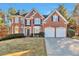 Brick two-story house with a three-car garage and manicured lawn at 5506 Sara Creek Ln, Sugar Hill, GA 30518