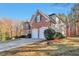 Side view of a brick house with a three-car garage at 5506 Sara Creek Ln, Sugar Hill, GA 30518