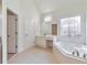 Main bathroom with soaking tub, walk-in shower, and stained glass window at 5506 Sara Creek Ln, Sugar Hill, GA 30518