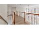 Bright upper hallway with hardwood floors and wooden railings at 5506 Sara Creek Ln, Sugar Hill, GA 30518