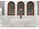 Modern bathroom featuring a stylish freestanding bathtub and arched windows at 1598 W Sussex Ne Rd, Atlanta, GA 30306