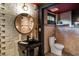 Basement bathroom with exposed brick, a black vanity, and a round mirror at 1598 W Sussex Ne Rd, Atlanta, GA 30306