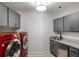 Laundry room with gray cabinets, red appliances, and a utility sink at 1598 W Sussex Ne Rd, Atlanta, GA 30306