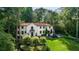 Aerial view of an estate home with white stucco, terra cotta roof, and green shutters surrounded by mature trees at 1598 W Sussex Rd, Atlanta, GA 30306