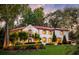 Expansive home exterior with white stucco, terra cotta roof, green shutters, mature landscaping, and manicured lawn at 1598 W Sussex Rd, Atlanta, GA 30306