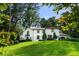 Expansive home exterior with white stucco, terra cotta roof, green shutters, and meticulously manicured lawn at 1598 W Sussex Rd, Atlanta, GA 30306