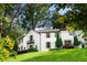 Expansive home exterior with white stucco, terra cotta roof, green shutters, and meticulously manicured lawn at 1598 W Sussex Rd, Atlanta, GA 30306