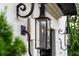 Close-up of gas lamps on a white brick home with black iron hardware and a manicured green bush visible at 1598 W Sussex Rd, Atlanta, GA 30306