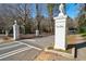 Street view of the Lenox Park entrance marked by white brick pillars with urns on top and Lenox Park sign at 1598 W Sussex Rd, Atlanta, GA 30306