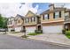 Row of townhouses featuring attached garages and manicured lawns at 53 Providence Oak Ct, Lawrenceville, GA 30046