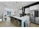 Open-concept kitchen featuring island with bar seating, stainless steel appliances, and adjacent living area at 711 Needletail Way, Atlanta, GA 30312