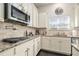 Kitchen detail showing granite countertops, gas cooktop, and stainless steel microwave at 105 Couch Ct, Fayetteville, GA 30214