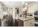 Open kitchen with island, view into adjacent dining area, and hardwood floors at 105 Couch Ct, Fayetteville, GA 30214