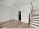 Bright bonus room with wood-look floors, modern door, and staircase at 2335 Mason Dr # D27, Atlanta, GA 30316