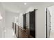 Upstairs hallway with barn doors and a modern metal railing at 2335 Mason Dr # D27, Atlanta, GA 30316