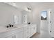 Bright bathroom featuring a double sink vanity with white cabinets and black hardware at 3072 Kelly St, Scottdale, GA 30079