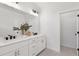 Bright bathroom featuring a double sink vanity with white cabinets and black hardware at 3072 Kelly St, Scottdale, GA 30079