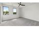 Spacious bedroom featuring carpet floors, two windows, and a ceiling fan at 3072 Kelly St, Scottdale, GA 30079