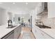 Modern kitchen featuring white cabinets, stainless steel appliances, and a view to the dining area at 3072 Kelly St, Scottdale, GA 30079