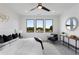 Bright main bedroom featuring a ceiling fan, three large windows, and an ensuite bathroom at 3072 Kelly St, Scottdale, GA 30079