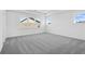 A bright, airy bedroom featuring recessed lighting, plush gray carpeting, and multiple windows at 6210 Misty Hill Ln, Buford, GA 30518