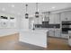 Modern kitchen with a large island, stainless steel appliances, pendant lights, and gray cabinetry at 6210 Misty Hill Ln, Buford, GA 30518