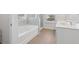 Elegant bathroom featuring double sinks, a walk-in shower, a tub and tile flooring at 1920 Pearson St, Loganville, GA 30052