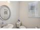 Bathroom featuring a sink, mirror, toilet, and window at 1920 Pearson St, Loganville, GA 30052