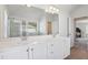 Bright bathroom with double vanity, white cabinets, and a large mirror complemented by modern lighting at 1920 Pearson St, Loganville, GA 30052