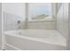 Bright bathtub with white fixtures and neutral tilework, creating a clean and comfortable space at 1920 Pearson St, Loganville, GA 30052