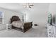 Spacious bedroom with a ceiling fan, plush carpeting, and a large dark wood bed frame at 1920 Pearson St, Loganville, GA 30052
