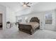 Large bedroom showing a ceiling fan, carpeting, windows, and dark wood bed frame at 1920 Pearson St, Loganville, GA 30052