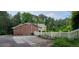 Long driveway with a white picket fence with a well-maintained brick house and lush greenery at 1294 Dogwood Rd, Snellville, GA 30078