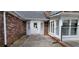 Exterior view of a brick house with new roof, white trim, and glass paned doors to the sun room at 1294 Dogwood Rd, Snellville, GA 30078