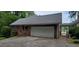 Attached two-car garage with brick siding, new roof, and a driveway for ample parking space at 1294 Dogwood Rd, Snellville, GA 30078