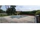 Outdoor pool with a cover, mature trees, and a volleyball net surrounded by black metal fence at 1294 Dogwood Rd, Snellville, GA 30078