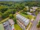 Aerial view of modern townhomes with lush green trees and landscaping, plus adjacent parking lot at 3076 Kelly St, Scottdale, GA 30079