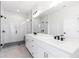 Modern bathroom with double vanity, tiled floors, and glass shower with bench at 3076 Kelly St, Scottdale, GA 30079