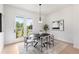 Dining area with a round table, chic chairs, modern art, and a bright view through the door at 3076 Kelly St, Scottdale, GA 30079