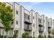 Modern townhouse showcasing clean architectural lines, balconies, and a landscaped yard at 3076 Kelly St, Scottdale, GA 30079