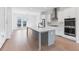 Modern kitchen with stainless steel appliances, quartz countertops, and a large center island with bar seating at 3076 Kelly St, Scottdale, GA 30079